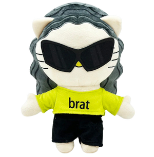 Plush toy resembling a cat with sunglasses and a 'brat' shirt on a white background