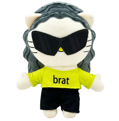 Plush toy resembling a cat with sunglasses and a 'brat' shirt on a white background